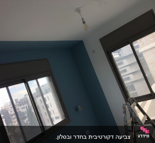 קיר צבוע בכחול וסולם בחדר
